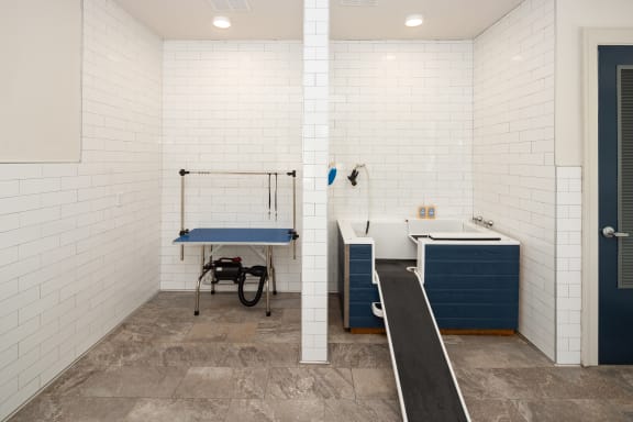 a locker room with a sink and a bath tub and aigmigmigmot
