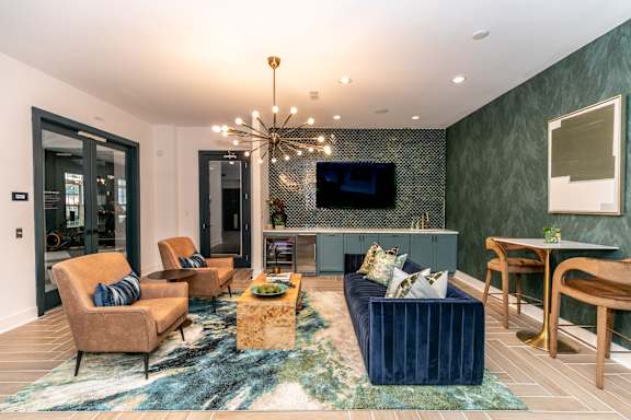 A living room with a blue rug and a chandelier.