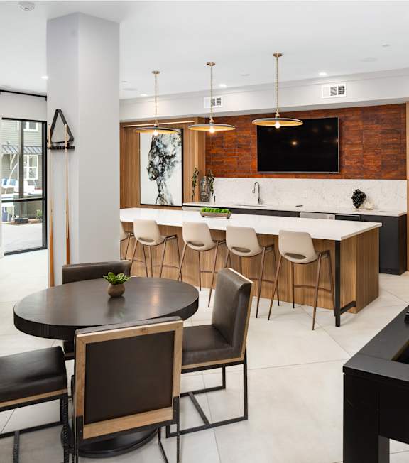 the kitchen and dining area of a modern house with a pool table
