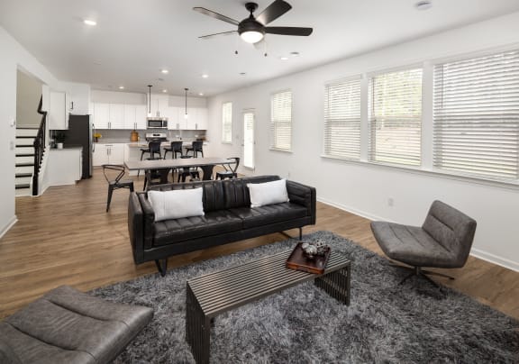 a living room with a couch and a chair and a dining room table