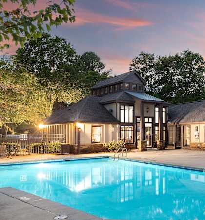 a swimming pool in front of a house with a pool