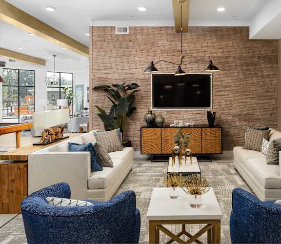 A living room with a brick wall and a flat screen TV mounted above a wooden cabinet.