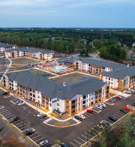 an aerial view of an apartment complex and parking lot
