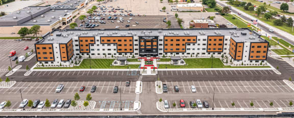 an aerial view of a large parking lot with cars parked in front of it