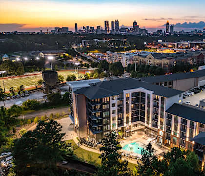 an aerial view of a building with a city skyline in the background