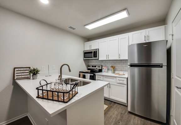 a kitchen with white cabinetry and stainless steel appliances