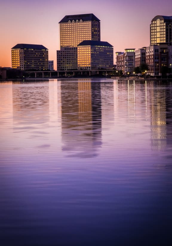 a view of the city skyline from the water at dusk