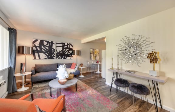a living room with orange furniture and a large at Olympus Park Apartments, Roseville, CA