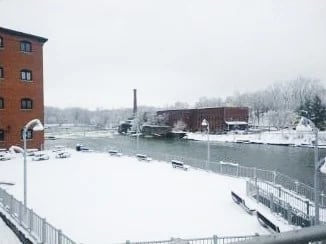 a view of a river with a building in the snow