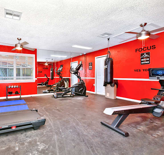 a workout room with red walls and exercise equipment