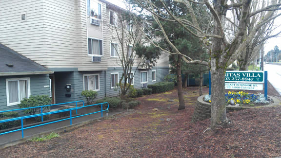 the apartment building has a sign for thetis villa in front of it