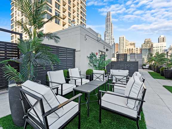 A patio with white furniture and a palm tree at Chateau on Wells, Chicago, Illinois