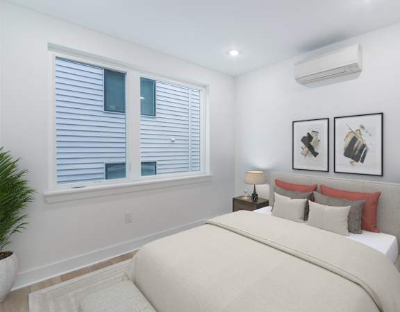 A bedroom with a large bed, two nightstands, and a window with blinds.