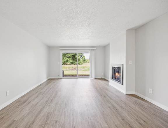 A spacious room with a fireplace and sliding glass doors.