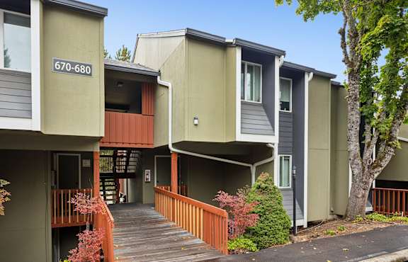 Apartment complex with a wooden walkway between the buildings.
