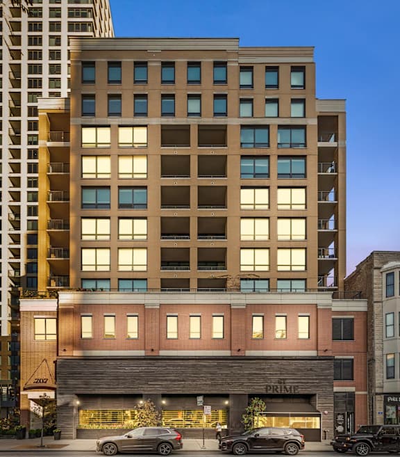 A modern building with a parking lot in front of it. at Chateau on Wells, Chicago, Illinois