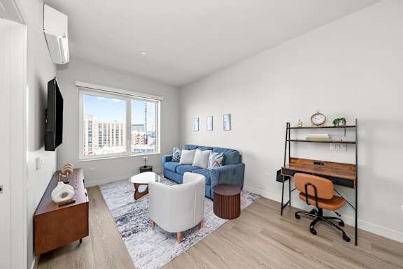 A living room with a blue couch and a white chair.