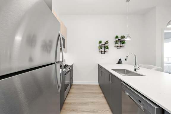 A modern kitchen with a stainless steel refrigerator and a white countertop.
