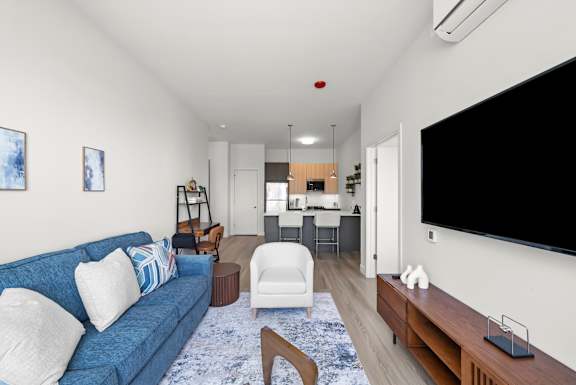A living room with a blue couch and a white chair.