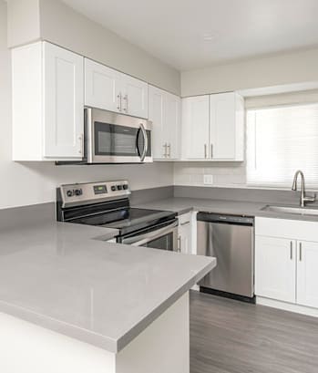 a kitchen with white cabinets and stainless steel appliances