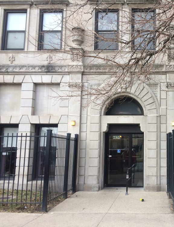the front of a building with a black fence and gate