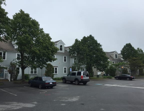 a parking lot with cars in front of houses