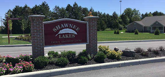A sign for Shawnee Lakes is shown in front of a grassy area.