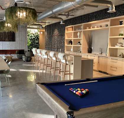 A pool table with a green cloth and a set of pool balls on it.