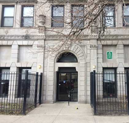 the front of a building with a black fence and gate