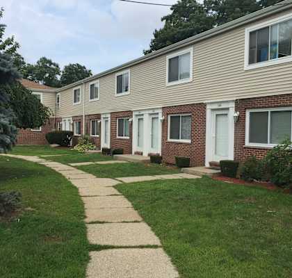 a sidewalk in front of a row of houses