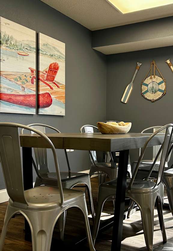 A dining room with a wooden table and chairs.