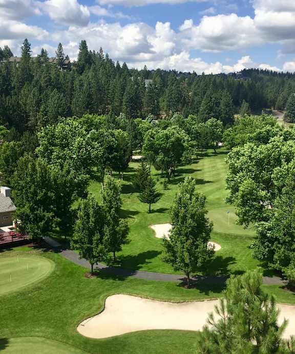 A golf course with a green and a sand trap.