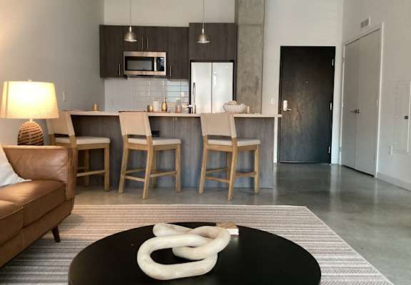 A modern living room with a black coffee table and a white sculpture on it.