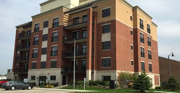 an apartment building on the corner of a parking lot