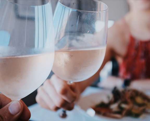 a table with a plate of food and a glass of wine
