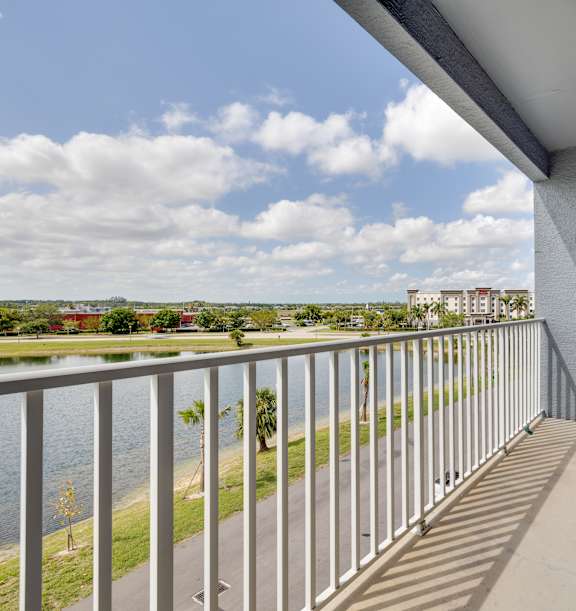 A balcony with a metal railing overlooks a body of water.