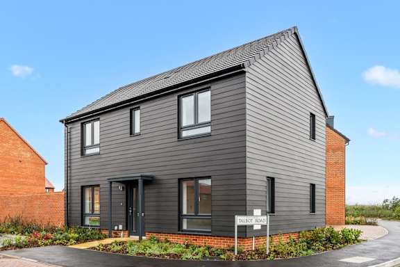 A modern house with a grey exterior and a black door.