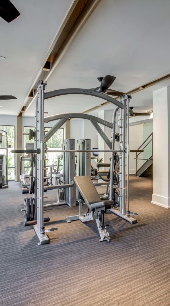a gym with weights and other exercise equipment in a building with stairs