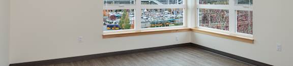 A room with a large window overlooking a parking lot.