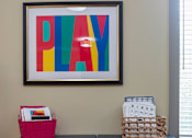 Thumbnail 53 of 54 - A black dresser with a pink basket on top and a colorful framed artwork above it.