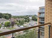 Thumbnail 5 of 5 - a view from a balcony of a city street with cars and buildings
