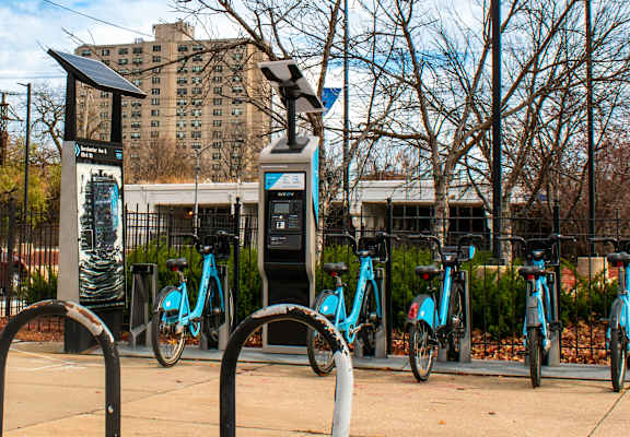 A row of bicycles are parked at a bike station.