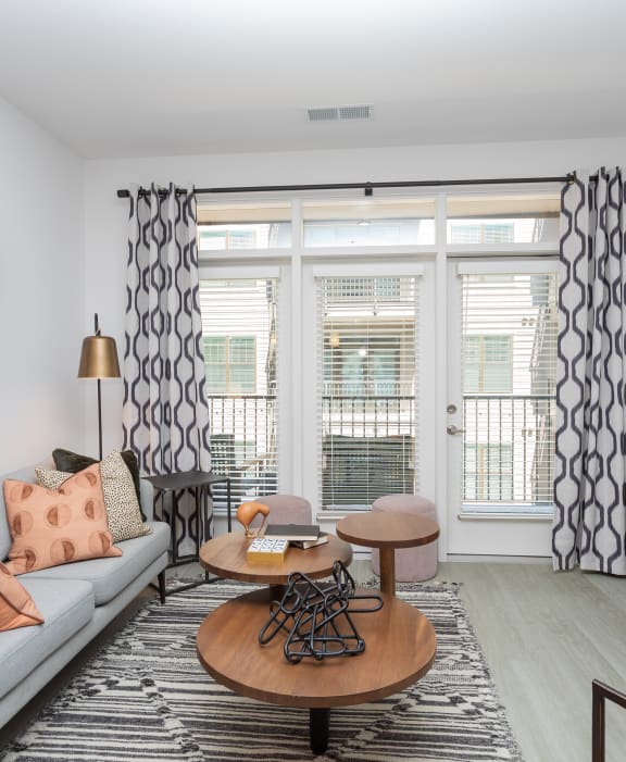 a living room with a couch and a tv and some windows  at Link Apartments® Canvas, Atlanta