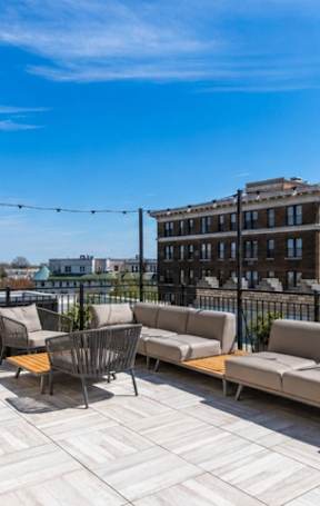 a rooftop deck with couches and tables on a sunny day  at Connecticut Gardens, Washington, DC