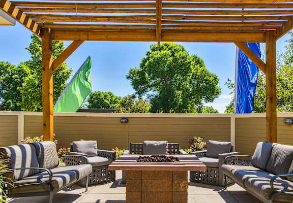 a patio with chairs and a table and a pergola