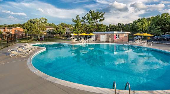 A large outdoor swimming pool with a yellow umbrella. at Charlestowne North Apartments, Maryland