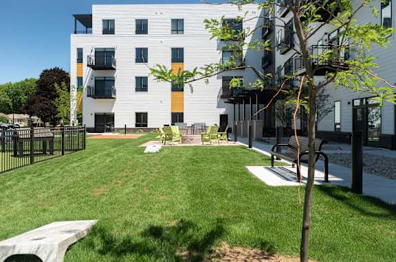 A modern apartment building with a green lawn in front.