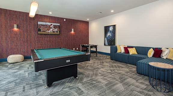 A room with a pool table and a couch.