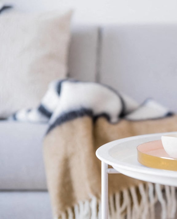a tray with two cups and a vase on a table in a living room