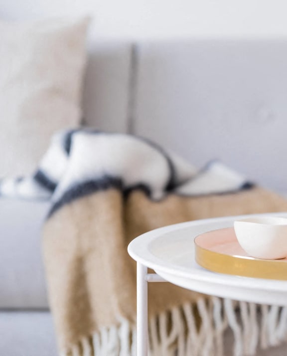 a tray with two cups and a vase on a table in a living room